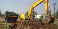 Excavator loading spoil material on a tipper truck in Block F, Soshanguve